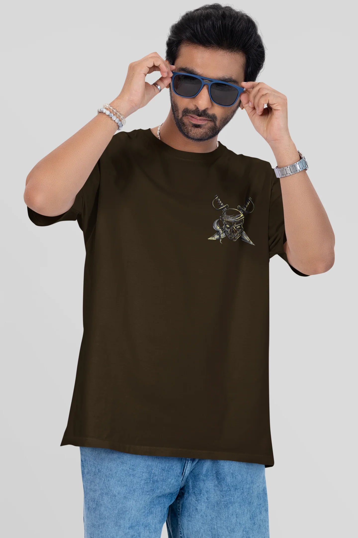 Man wearing a brown t-shirt with a graphic design on a plain background